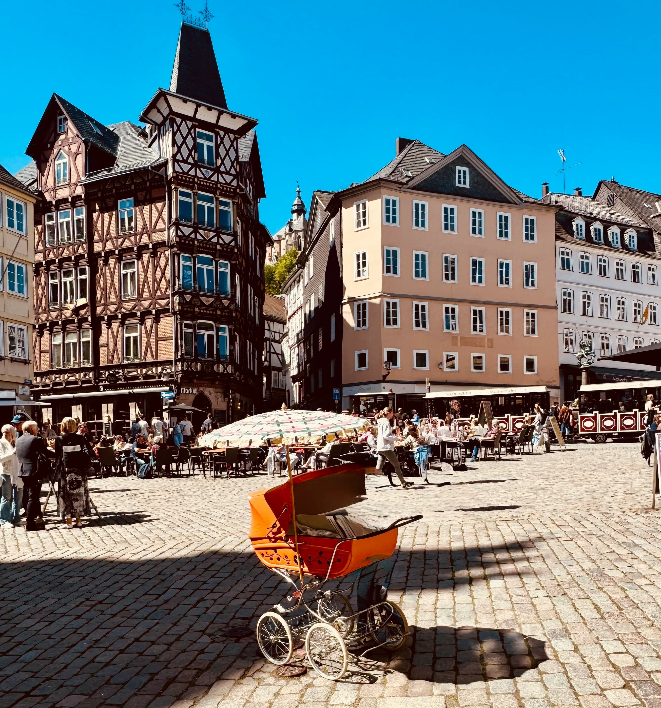 A pram on the cobblestones of a half-timbered German market square
