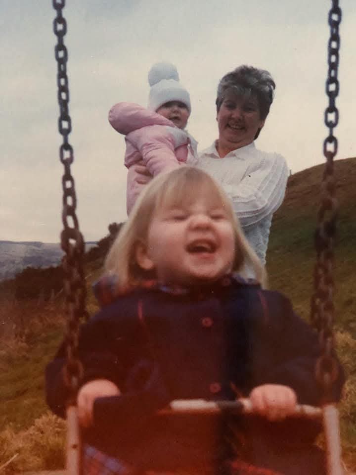 Emma as a child on a swing in Wales